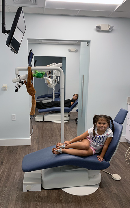 Happy children sitting in dental chairs.