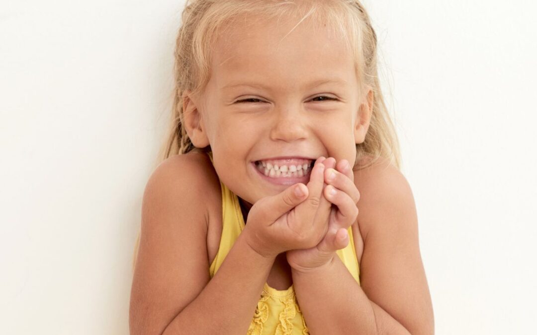 Child smiling while showing her permanent teeth during dental development